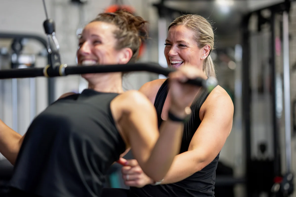 Kate, founder and head coach of KLT Fit, laughing with a client during a training session