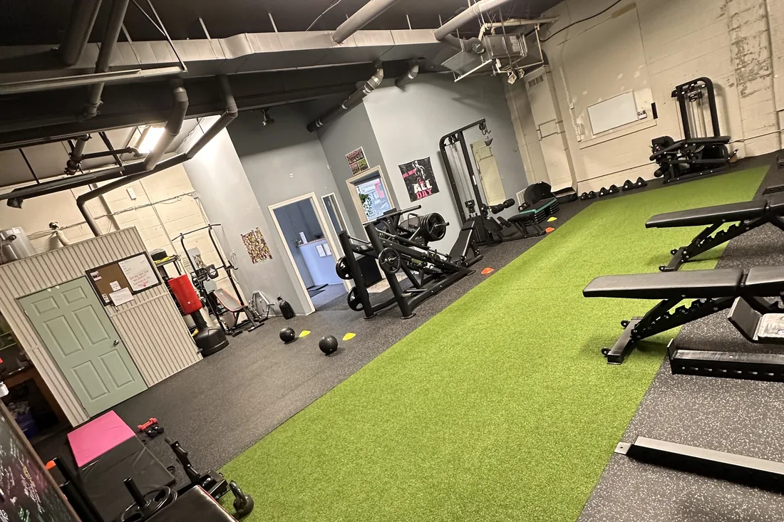Inside the KLT Fit studio in Peterborough, with turf, benches, and strength equipment